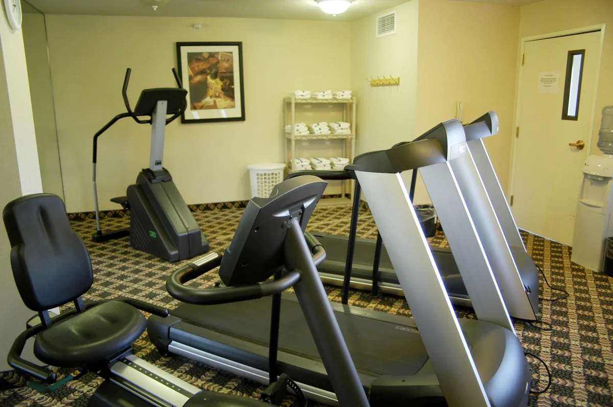 This bright, motivating fitness center features cardio equipment such as treadmills and an elliptical, complemented by a water cooler and uplifting artwork. The energetic atmosphere is ideal for guests looking to maintain their workout routines while traveling.